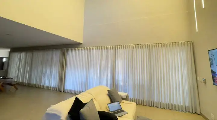 Cortina franzida instalada com precisão profissional em quarto sob medida